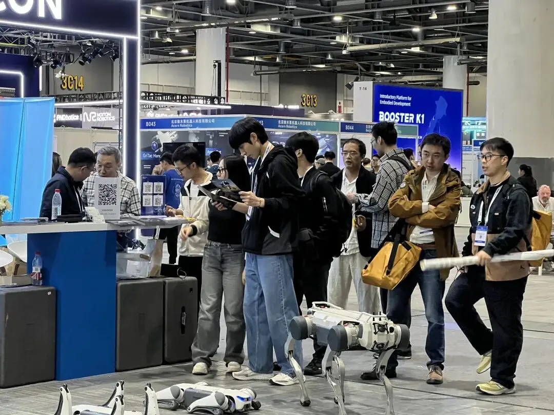 DEEP Robotics booth at IROS 2025 showcasing advanced quadruped robots, with visitors exploring the latest robotic innovations and autonomous walking systems.